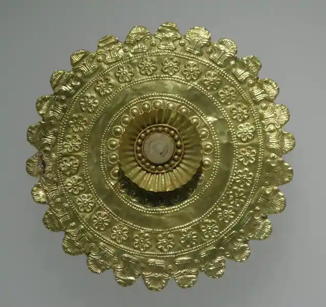 Gold circular plaque with six-pointed flower-like cross designs forming a circle